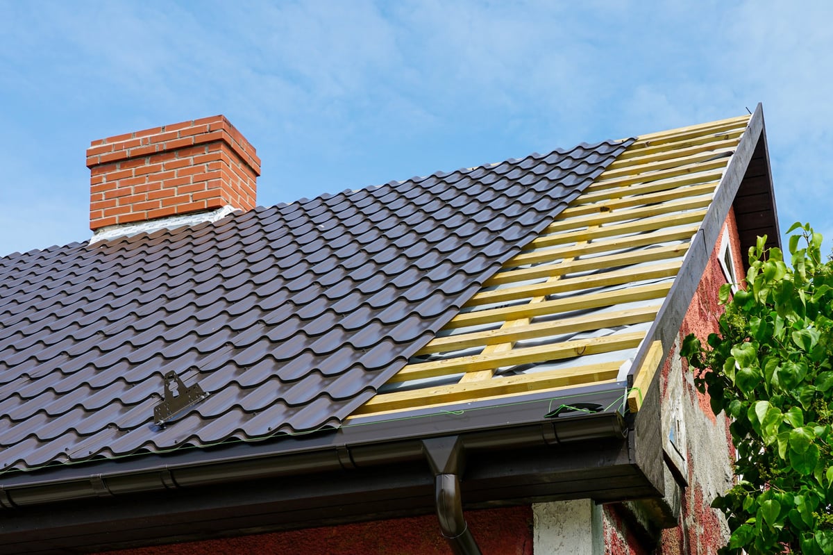 Close-up of tile roof repair work showing underlayment and battens