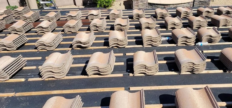 Stacks of curved clay roof tiles arranged on shelves in organized rows at an outdoor construction or tile storage facility